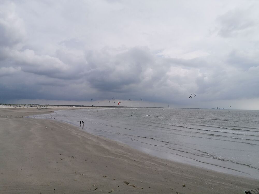 Wandelaars op het brede strand van IJmuiden aan Zee